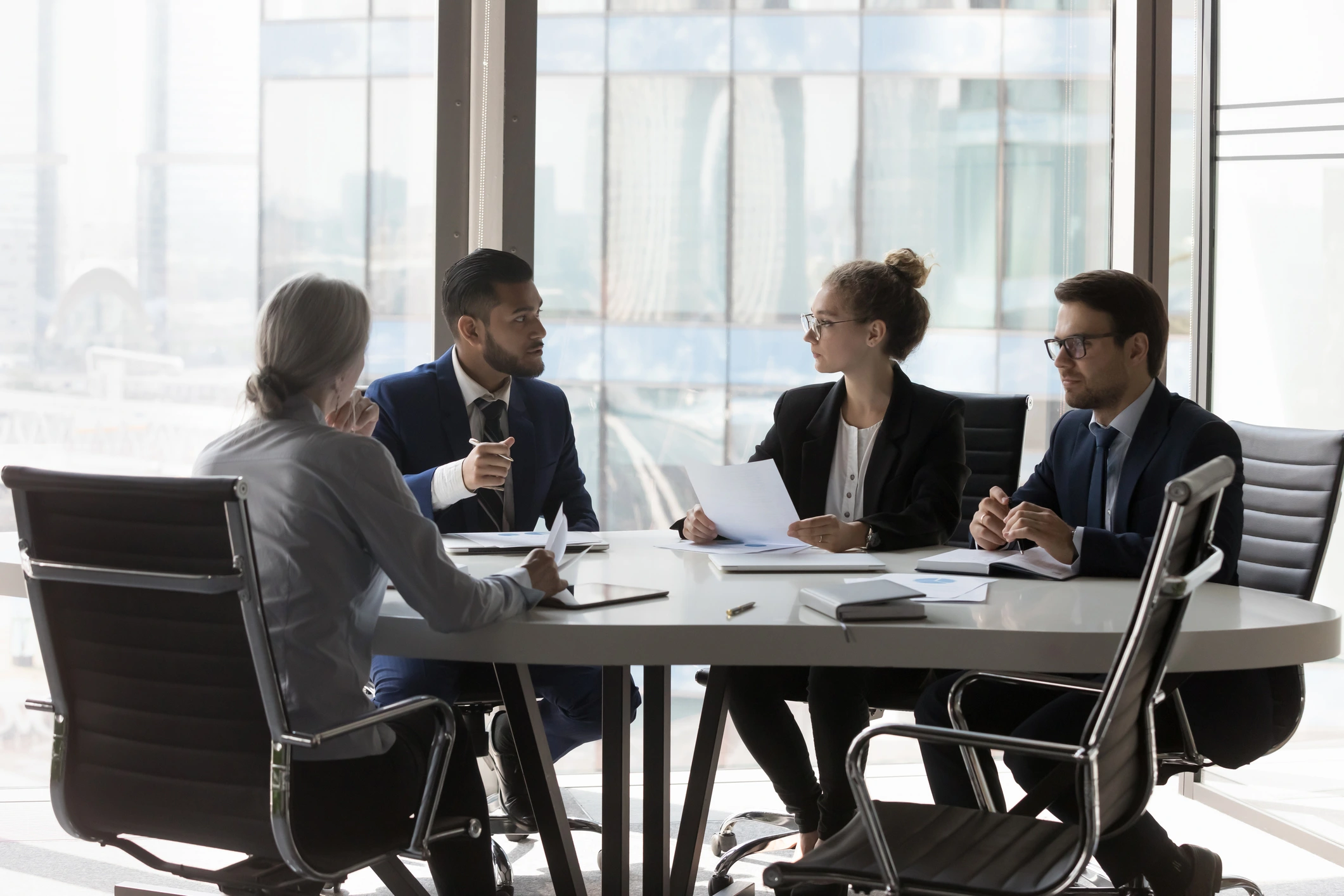 Business meeting with four people at table.