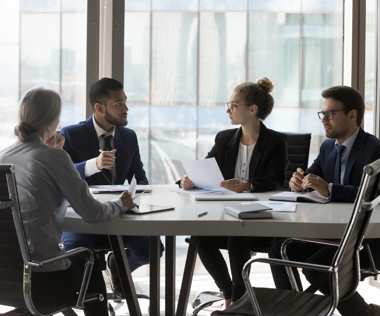 Business meeting with four professionals discussing.
