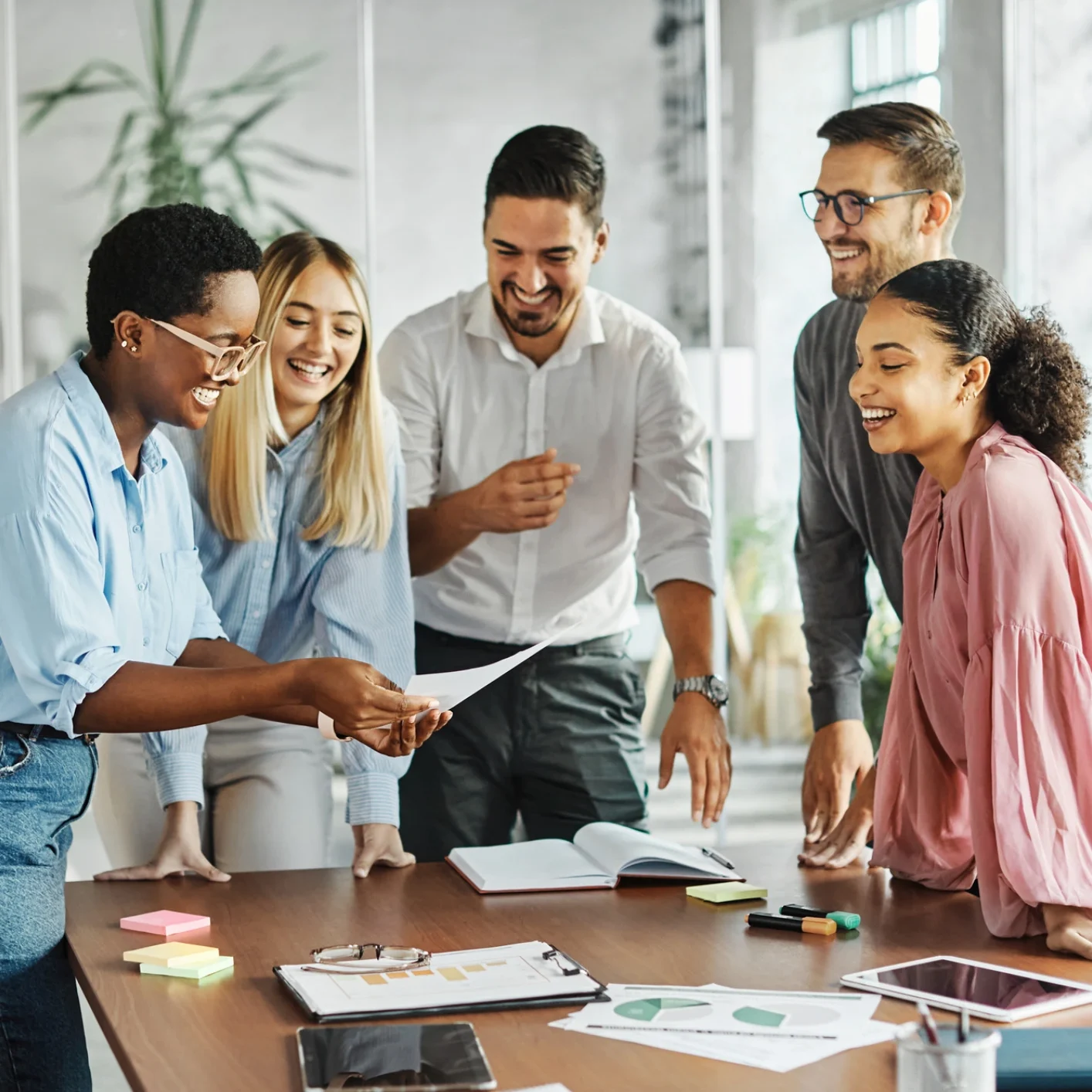 Group of colleagues laughing around a table.